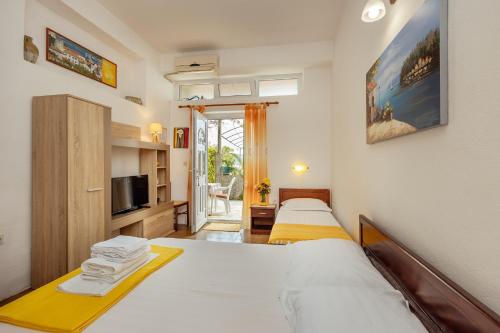 um quarto de hotel com duas camas e uma televisão em Suberic Apartments em Herceg Novi