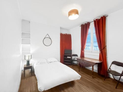 une chambre avec un lit blanc et une fenêtre dans l'établissement Vue Sur la Ville - Studio Angers - proche gare, à Angers