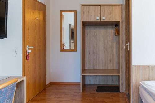 a small room with a door and a mirror at Hotel am Römerplatz in Ulm