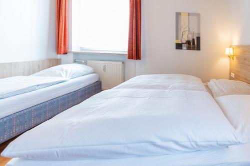 two beds sitting next to each other in a bedroom at Hotel am Römerplatz in Ulm