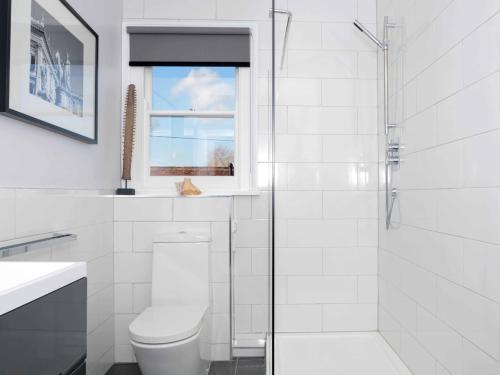 a white bathroom with a toilet and a shower at 5 Bed in Hurst Green 46916 in Robertsbridge