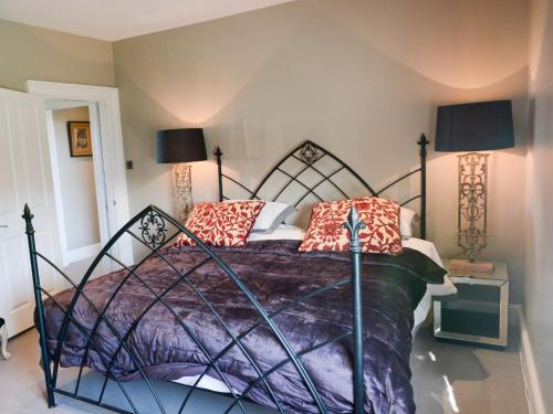 a bedroom with a bed with a purple comforter at 5 Bed in Hurst Green 46916 in Robertsbridge