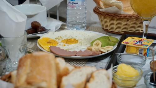 a table topped with a plate of eggs and bread at Résidence America in Dakhla