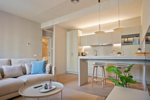 sala de estar y cocina con sofá y mesa en Fisa Rentals Ramblas Apartments, en Barcelona
