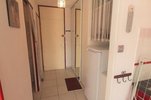 Cette chambre dispose d'un couloir avec un réfrigérateur blanc. dans l'établissement Studio 26, Héliopolis E au village naturiste, au Cap d'Agde