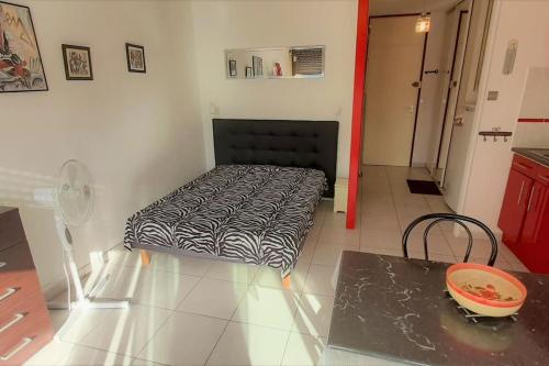 une chambre avec un lit dans le coin d'une pièce dans l'établissement Studio 26, Héliopolis E au village naturiste, au Cap d'Agde