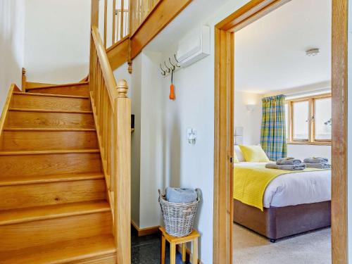 a bedroom with a staircase leading to a bed with yellow sheets at 2 Bed in Axminster 45099 in Axminster