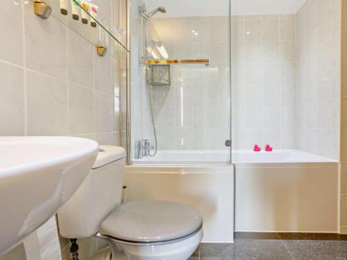 uma casa de banho com um WC, um chuveiro e um lavatório. em 2 Bed in Axminster 45099 em Axminster