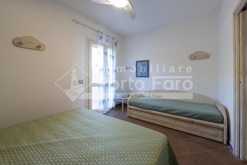 a bedroom with two beds and a door with a window at L301 - Bilocale caposchiera con giardino e vista sulla spiaggia di Porto Mannu in Palau