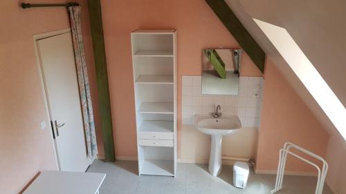 une petite salle de bain avec un lavabo et un évier dans l'établissement Chambre meublée en duplex indépendante, à Caen