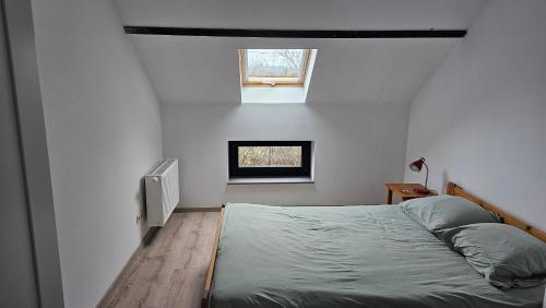 a small bedroom with a bed and a window at Casa Kakelbos in Rotselaar