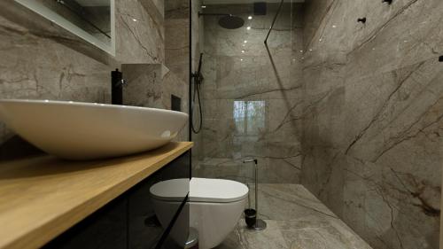 a bathroom with a white sink and a toilet at VacationClub - Siedem Wysp Apartament 31 in Sianozety