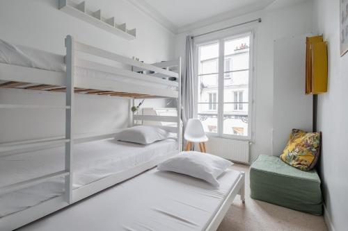 - une chambre avec 2 lits superposés et une chaise dans l'établissement Veeve - Flowers in Saint-Martin, à Paris