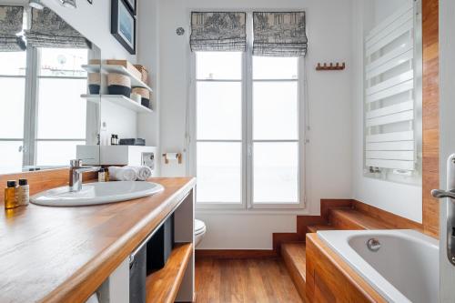 d'une cuisine avec un évier, une baignoire et des fenêtres. dans l'établissement Veeve - Flowers in Saint-Martin, à Paris