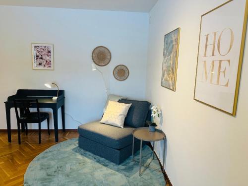 a living room with a blue chair and a table at Prinshöjden Hotel - Smart Digital Apartments & Villas in Katrineholm