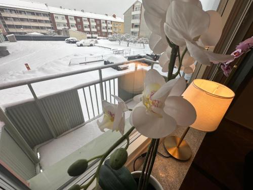 a vase with white flowers sitting on a window sill at Prinshöjden Hotel - Smart Digital Apartments & Villas in Katrineholm