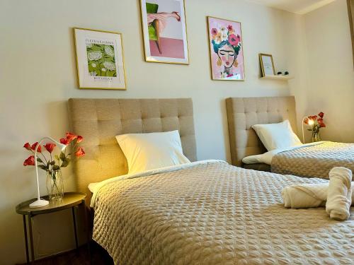 2 camas en un dormitorio con flores en una mesa en Pensionat Prinshöjden - Town en Katrineholm