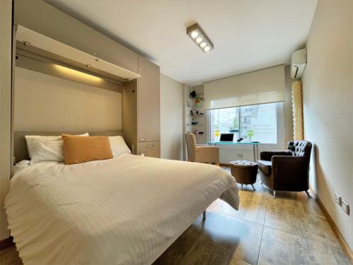 1 dormitorio con 1 cama blanca, escritorio y sillas en RENTAPART BA en Buenos Aires