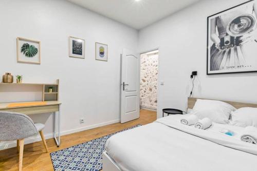 une chambre blanche avec un lit et un bureau dans l'établissement Appartement Familial proche Saint-Lazarre - 6P, à Paris