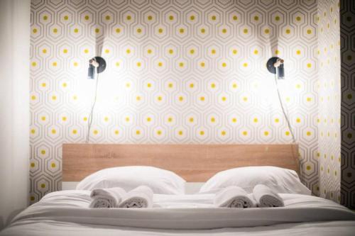 - un lit avec 2 oreillers blancs et un mur dans l'établissement Appartement Familial proche Saint-Lazarre - 6P, à Paris