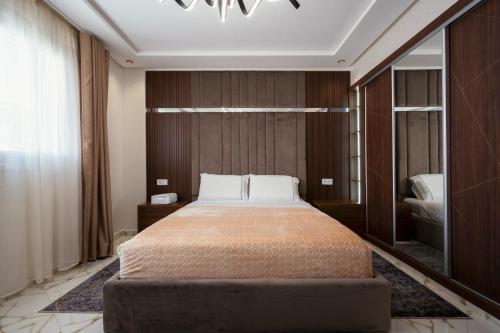 1 dormitorio con 1 cama grande y espejo en Apart Hotel IMMOKA, en Tánger