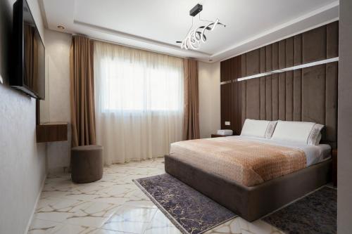 una habitación de hotel con una cama y un televisor en Appart-Hotel IMMOKA, en Tánger