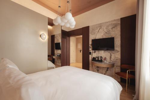 a bedroom with a white bed and a bathroom at Zenith Premium Suites in Thessaloniki
