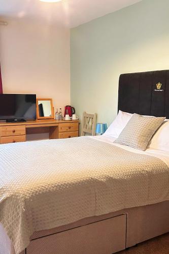 a bedroom with a large bed and a tv at Penybont Restaurant + Inn in Carmarthen