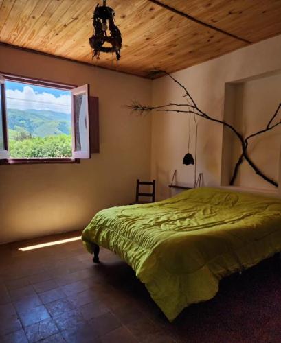 a bedroom with a green bed and a window at Casa Feito Tafi in Tafí del Valle