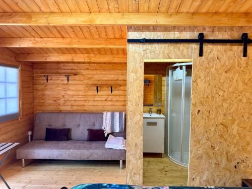 um quarto com um sofá numa casa de madeira em Camping Fonts del Algar em Callosa de Ensarriá