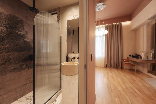 y baño con ducha de cristal y mesa. en Zenith Premium Suites, en Tesalónica
