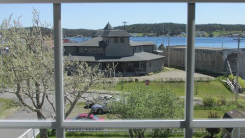 een raam met uitzicht op een gebouw bij Louisbourg Harbour Inn in Louisbourg