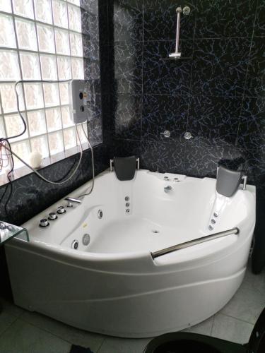 a white bath tub in a bathroom with a window at Habitación con jacuzzi, amoblado cama 3 plazas, escritorio, ropero y baño propio in Huancayo