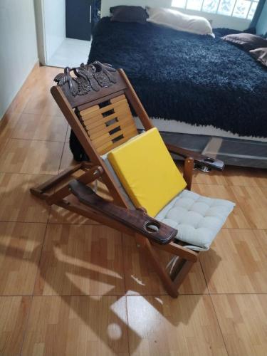 a wooden rocking chair sitting in a room with a bed at Habitación con jacuzzi, amoblado cama 3 plazas, escritorio, ropero y baño propio in Huancayo