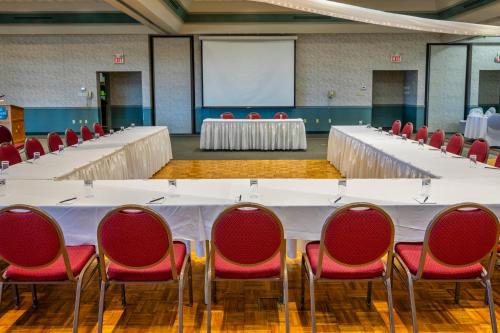 a conference room with a large white table and red chairs at Old Orchard Inn in Wolfville
