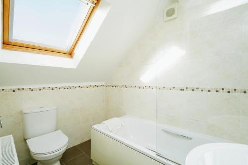 a bathroom with a toilet and a tub and a sink at Temple Apartment by Beds Away in Oxford