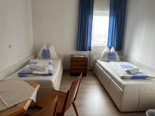 Habitación con 2 camas, mesa y sillas en Toskana Zimmer en Schwanenstadt