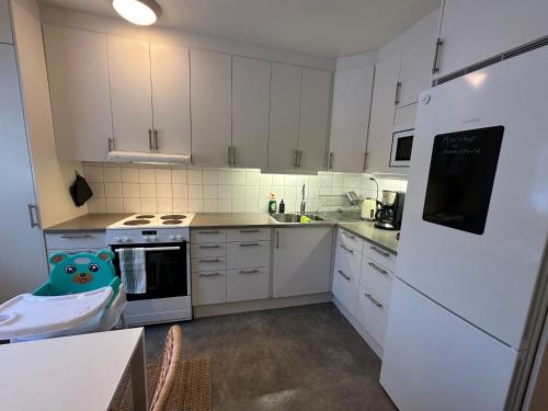a kitchen with white cabinets and a sink at Prinshöjden Hotel - Smart Digital Apartments & Villas in Katrineholm