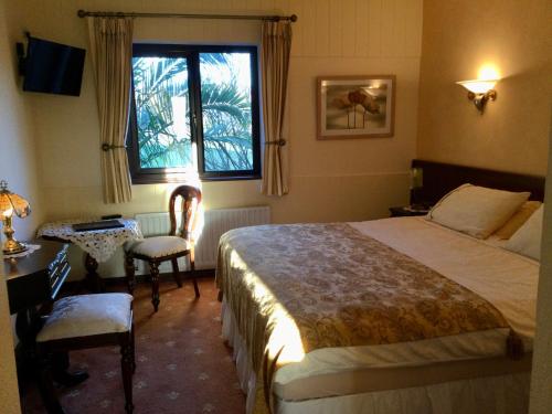 1 dormitorio con cama, mesa y ventana en Corthna Lodge en Schull