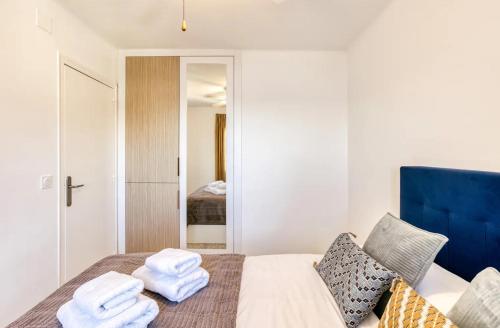 a bedroom with a bed with towels on it at Can Estrellas, appartement d'exception sur la mer in Roses
