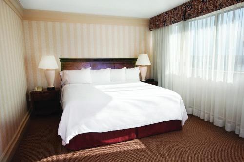 a large bed in a hotel room with two lamps at Clifton Victoria Inn at the Falls in Niagara Falls