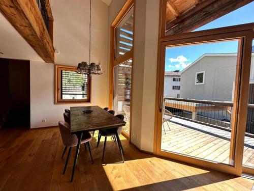 a dining room with a table and a large window at Stylish chalet w/Sauna: Alpine escape in Tinzen