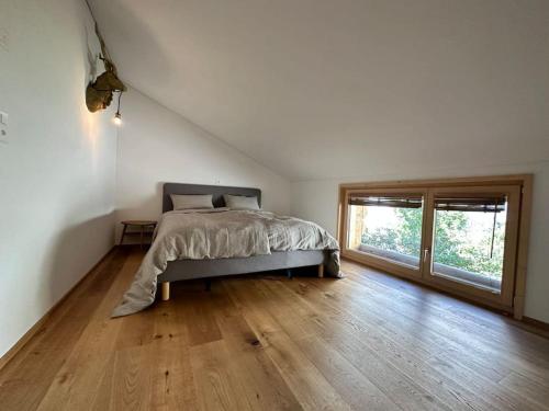 a bedroom with a bed and a wooden floor at Stylish chalet w/Sauna: Alpine escape in Tinzen