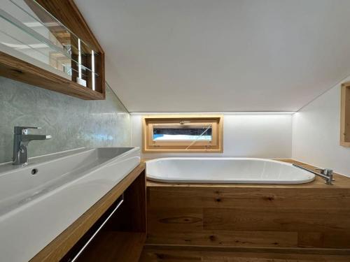 a large white tub in a bathroom with a sink at Stylish chalet w/Sauna: Alpine escape in Tinzen