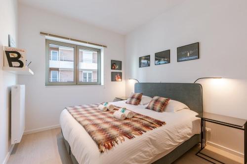 a bedroom with a bed with a blanket on it at Huswell - Brand new apartment with terrace - pets welcome! in Ostend