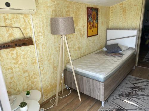 een kleine slaapkamer met een bed en een lamp bij Apartmani Miljana in Bar