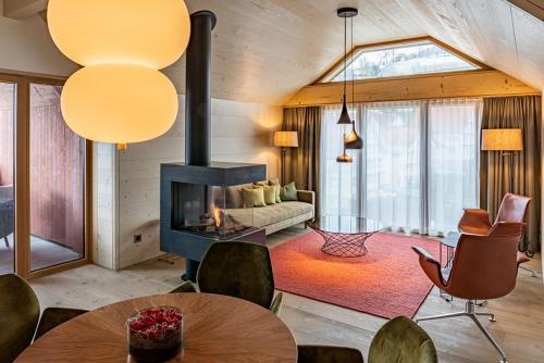 a living room with a fireplace and a table and chairs at Dorfhus Gupf in Rehetobel