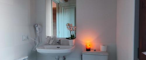 a bathroom with a sink and a candle on a toilet at la solana del abuelo Andrés 