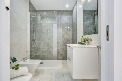 baño blanco con ducha y lavamanos en Luxury Romantic Ocean View en Adeje