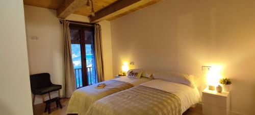 a bedroom with a bed and a window and two lamps at la solana del abuelo Andrés in La Chana